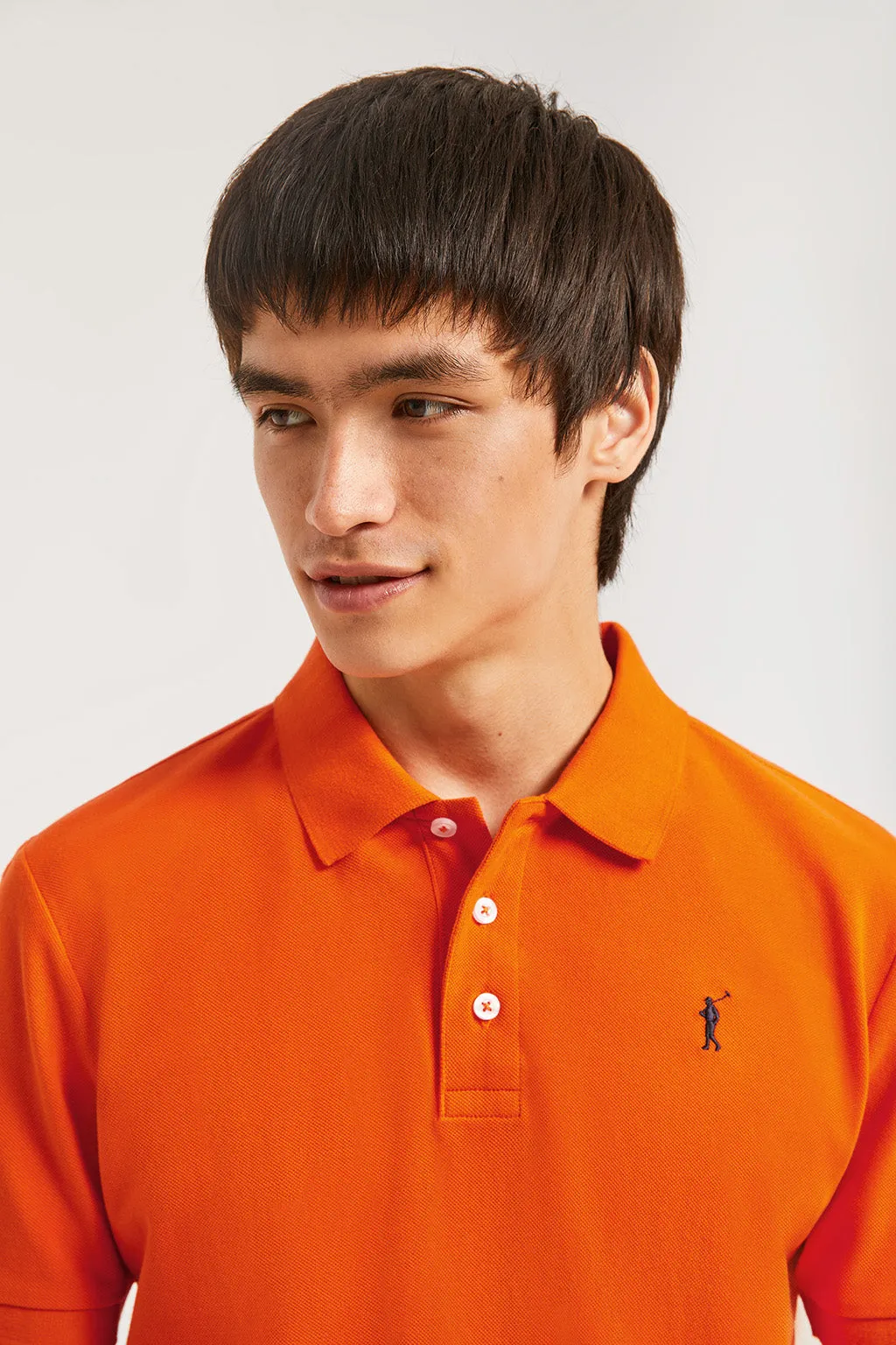 Polo  piqué naranja con tapeta de tres botones y logo bordado en contraste