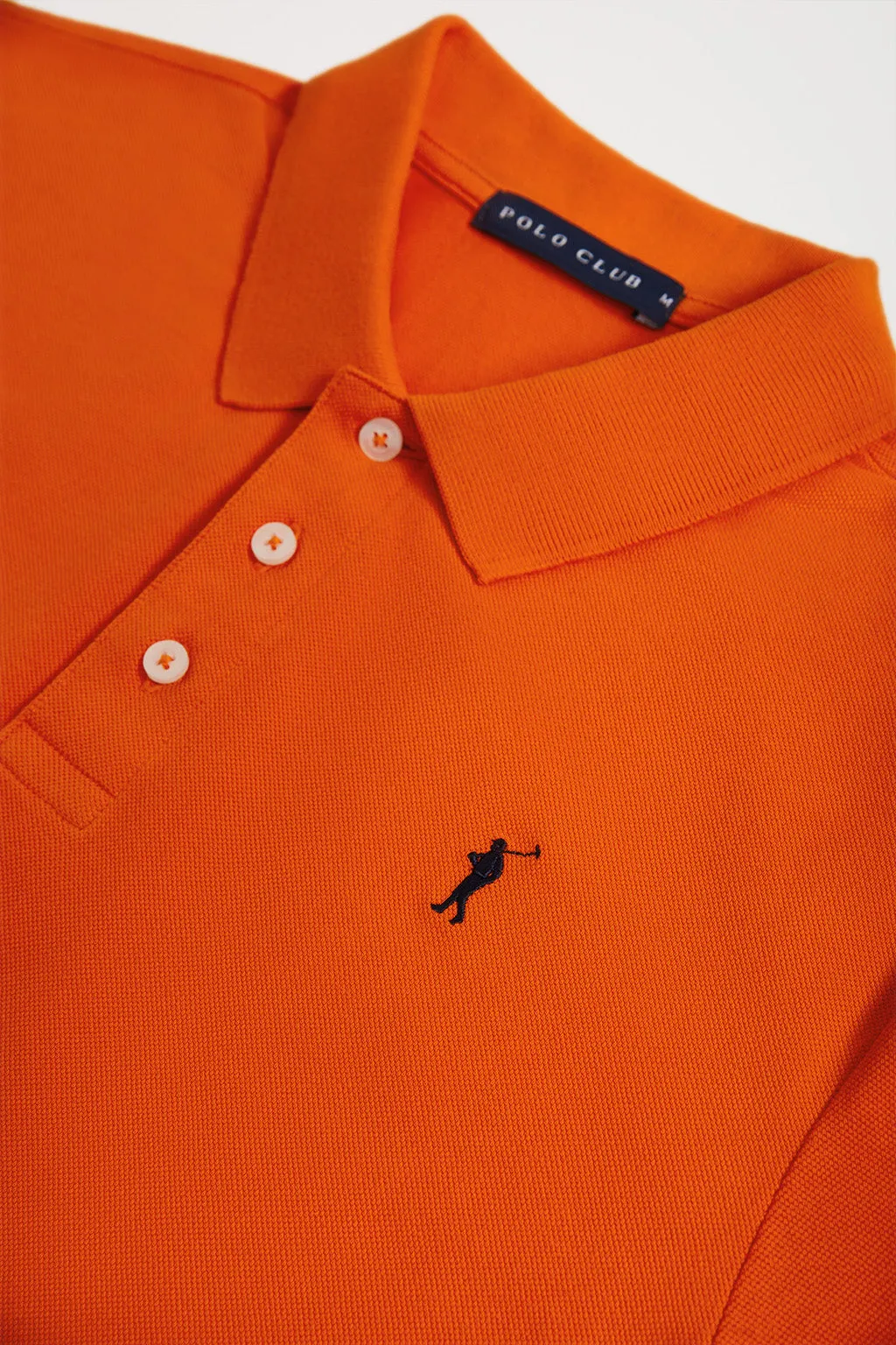 Polo  piqué naranja con tapeta de tres botones y logo bordado en contraste